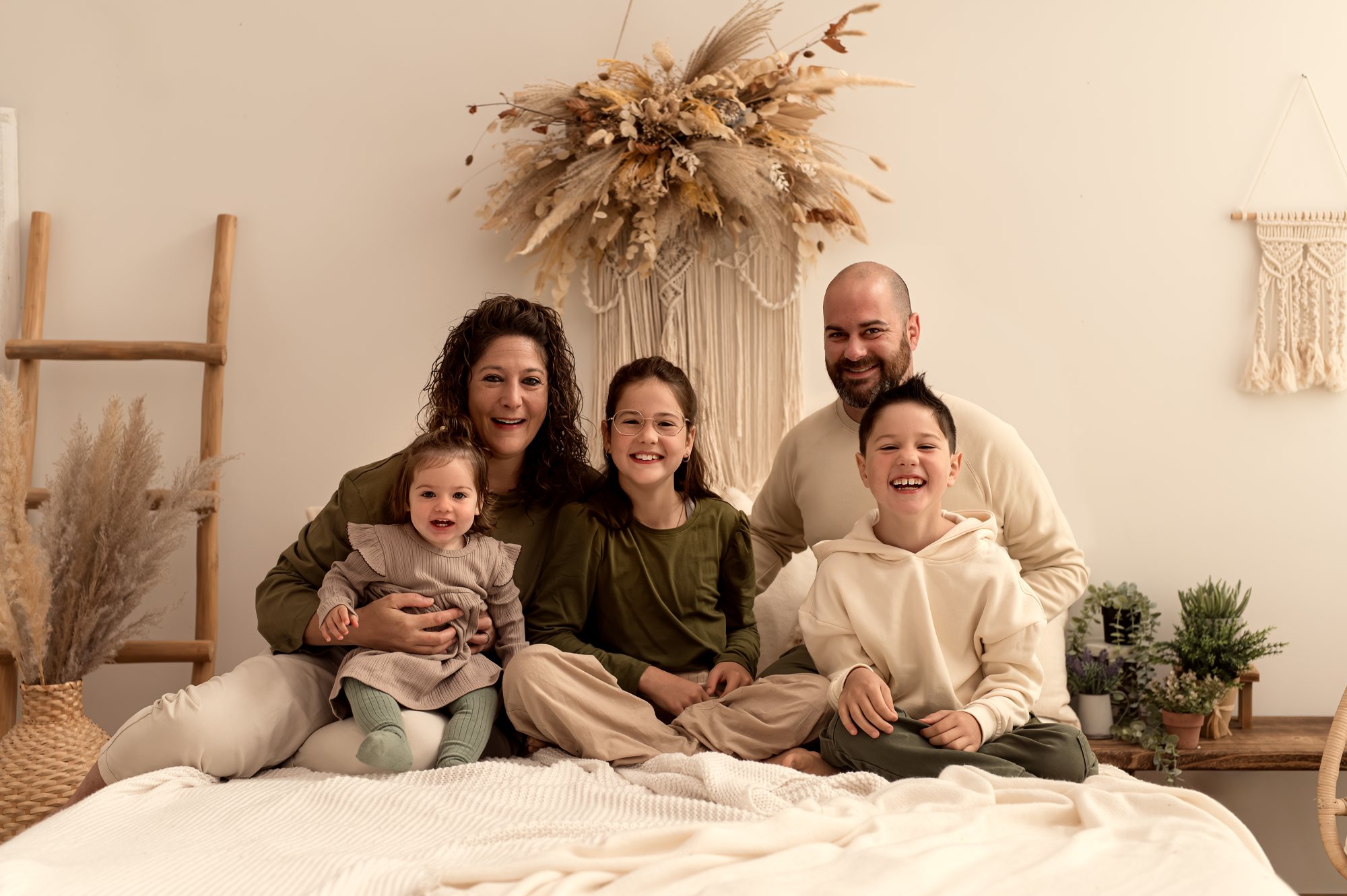 Familie mit drei Kindern auf dem Studio-Bett